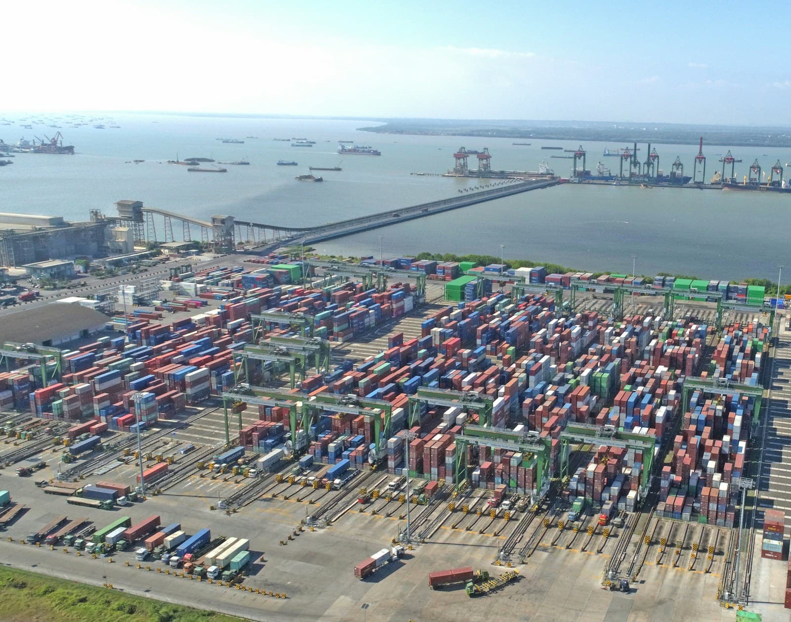 Container terminal with stacked containers and gantry cranes beside the water
