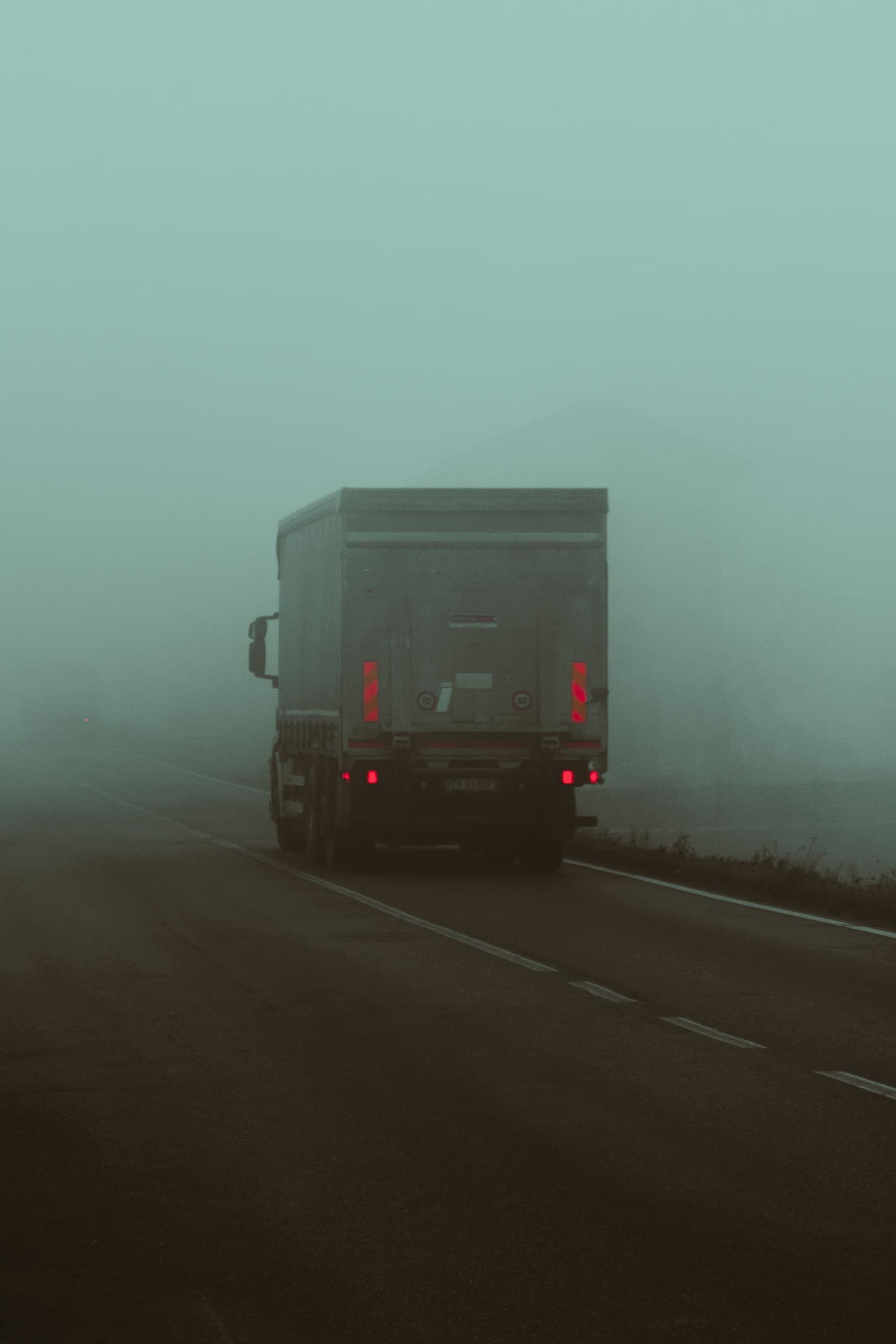 Box truck driving on a misty highway